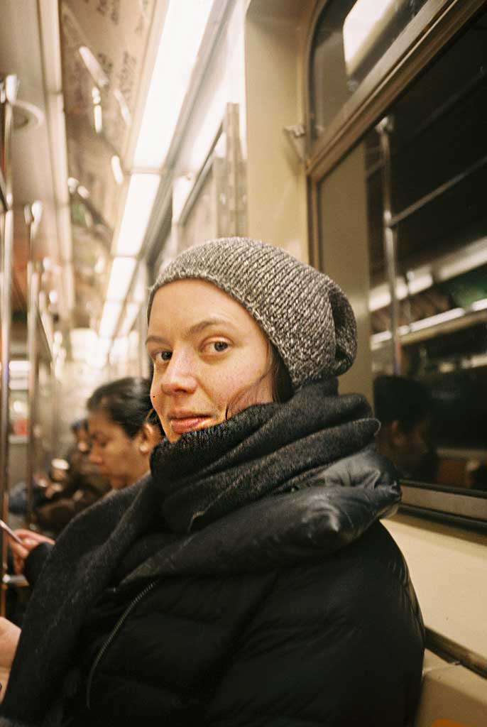 Photo of a Cool NYC women in her beanies on the subway taken by Brit Phelan Photography