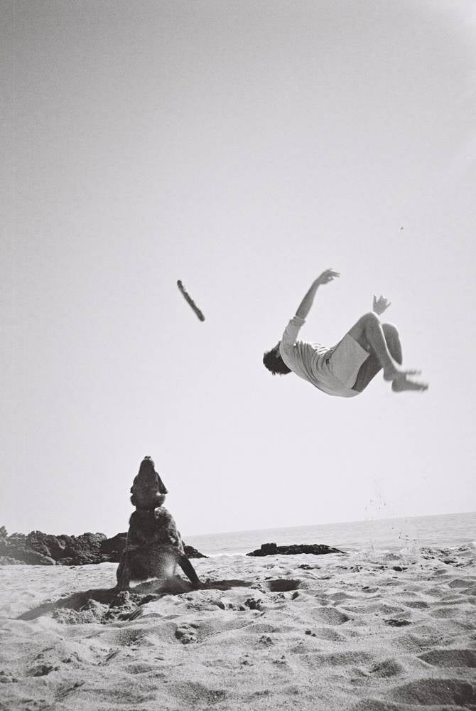 A dog and guy doing a flip on the beach photography by Brit Phelan