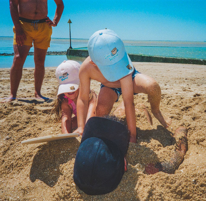  Kids playing on the beach in hats Brit Phelan Photography